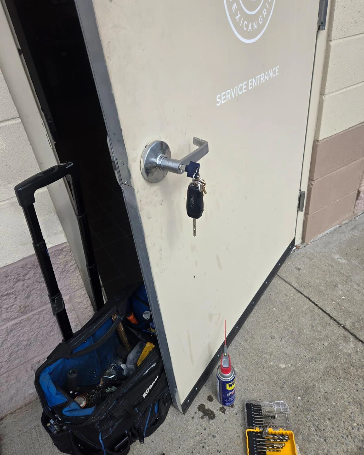 Commercial locksmith tools and lock service at a business entrance in Oshawa